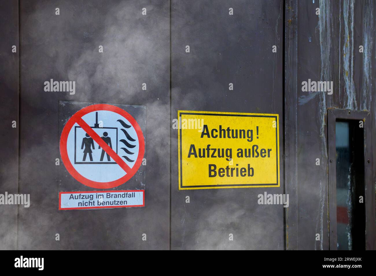 An einer Aufzugstür das Schild mit der deutschen Aufschrift, Achtung Aufzug außer Betrieb und zusätzlich nicht im Brandfall benutzen Stockfoto