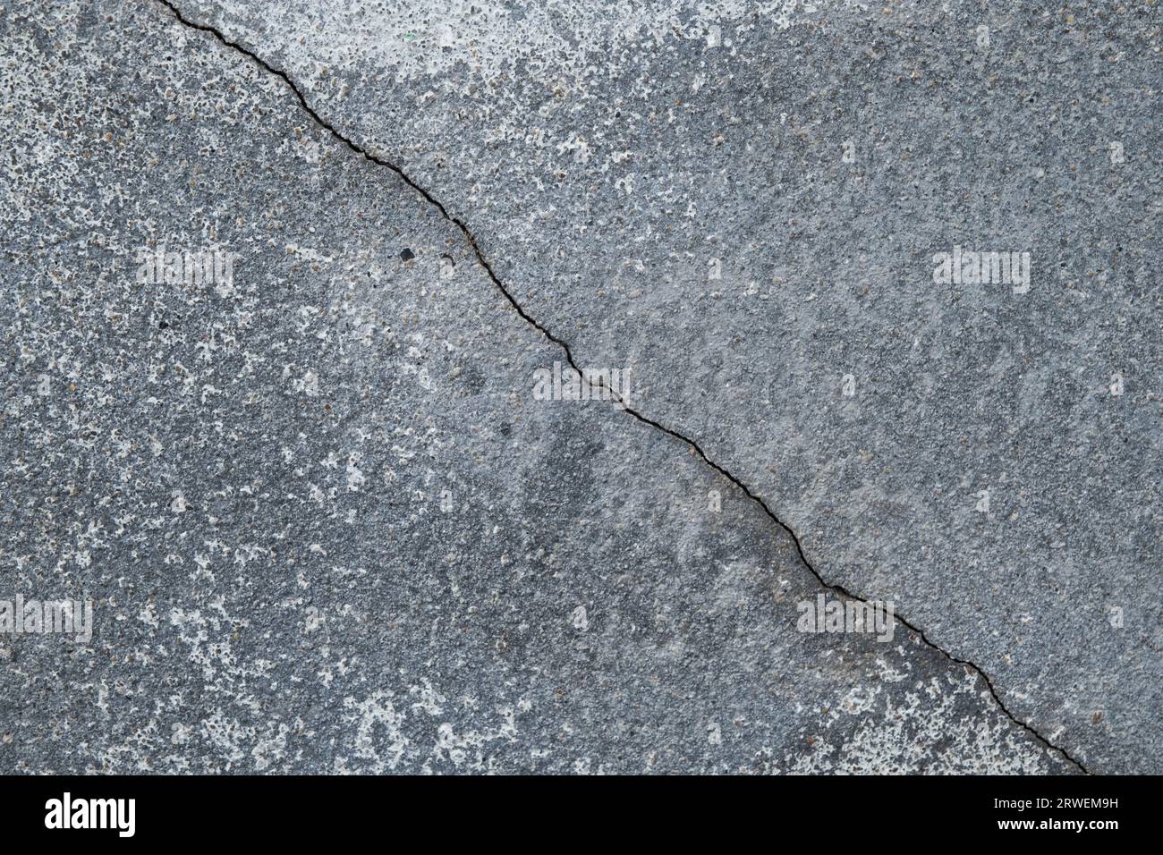 Grundieren Sie Wände oder Böden aus Zementbeton mit Rissen. Abstrakter Hintergrund der Rissbetonwand. Gerissener Beton-Hintergrund. Stockfoto