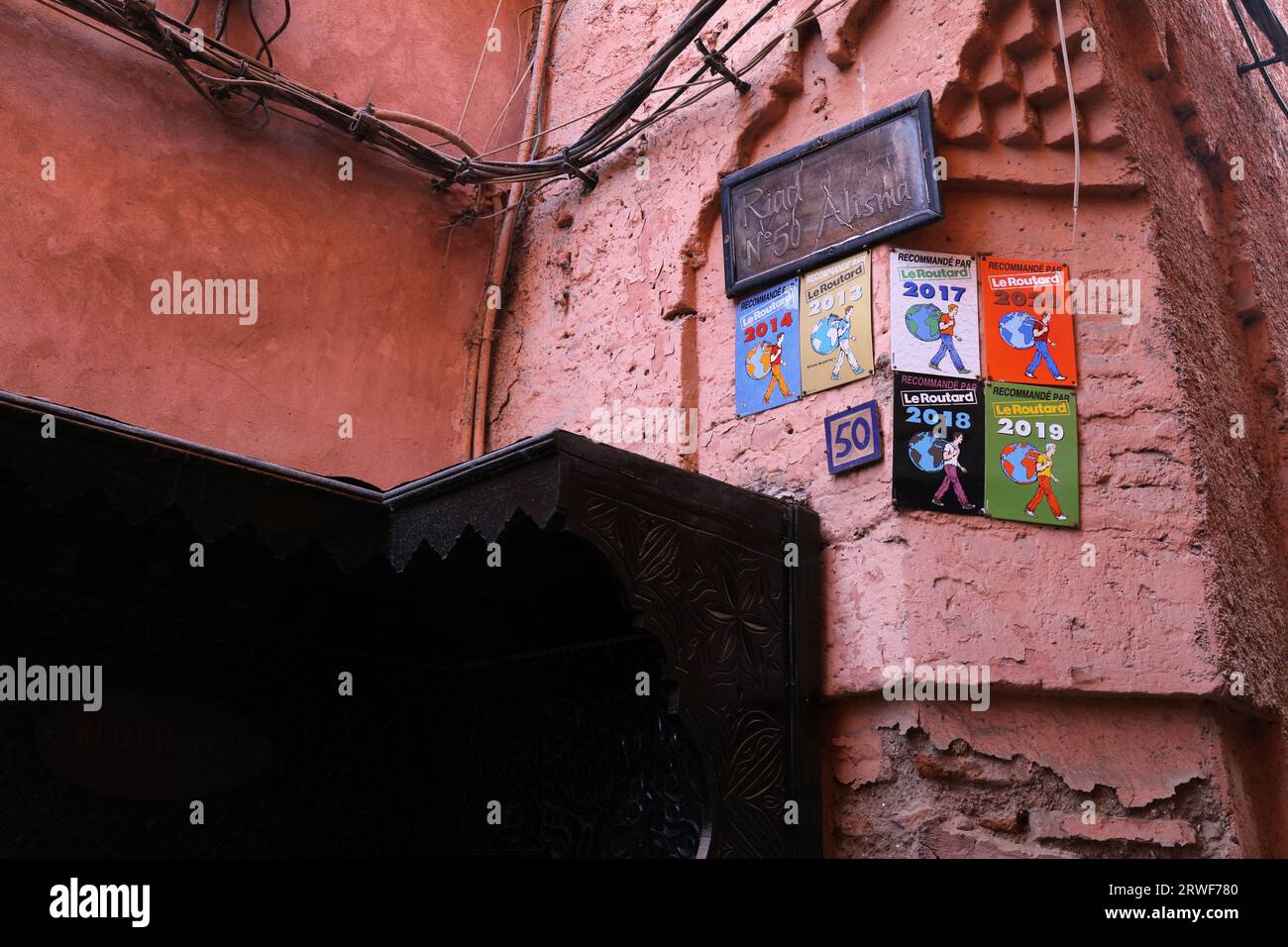 MARRAKESCH, MAROKKO - 20. FEBRUAR 2022: Schilder für Hotelempfehlungen von Le Routard an der Wand eines Riad-Hotels in Marrakesch, Marokko. Stockfoto