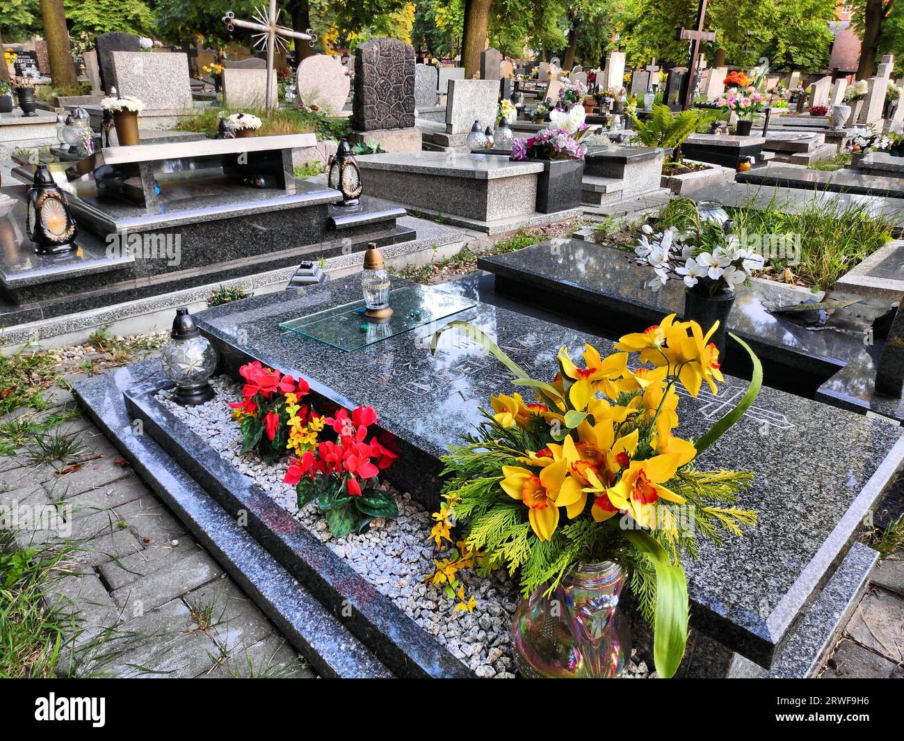 BYTOM, POLEN - 21. JULI 2022: Künstliche Blumendekoration auf einem Grab auf dem Friedhof in Bytom, Polen. Stockfoto