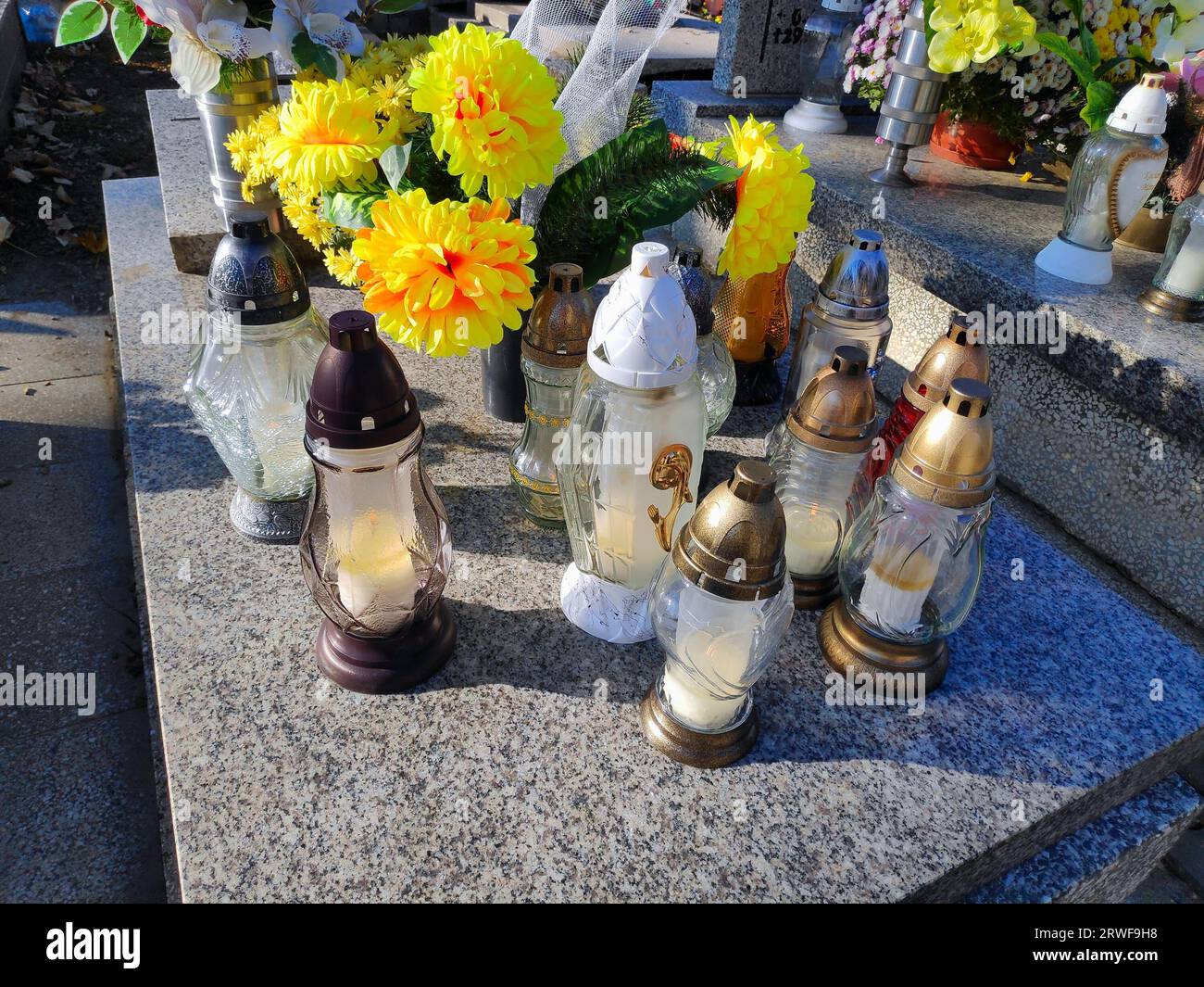 Grabkerzen auf einem Grab in Polen. Typische Friedhofsdekoration für Allerheiligen (Dzien Wszystkich Swietych) in Polen. Stockfoto