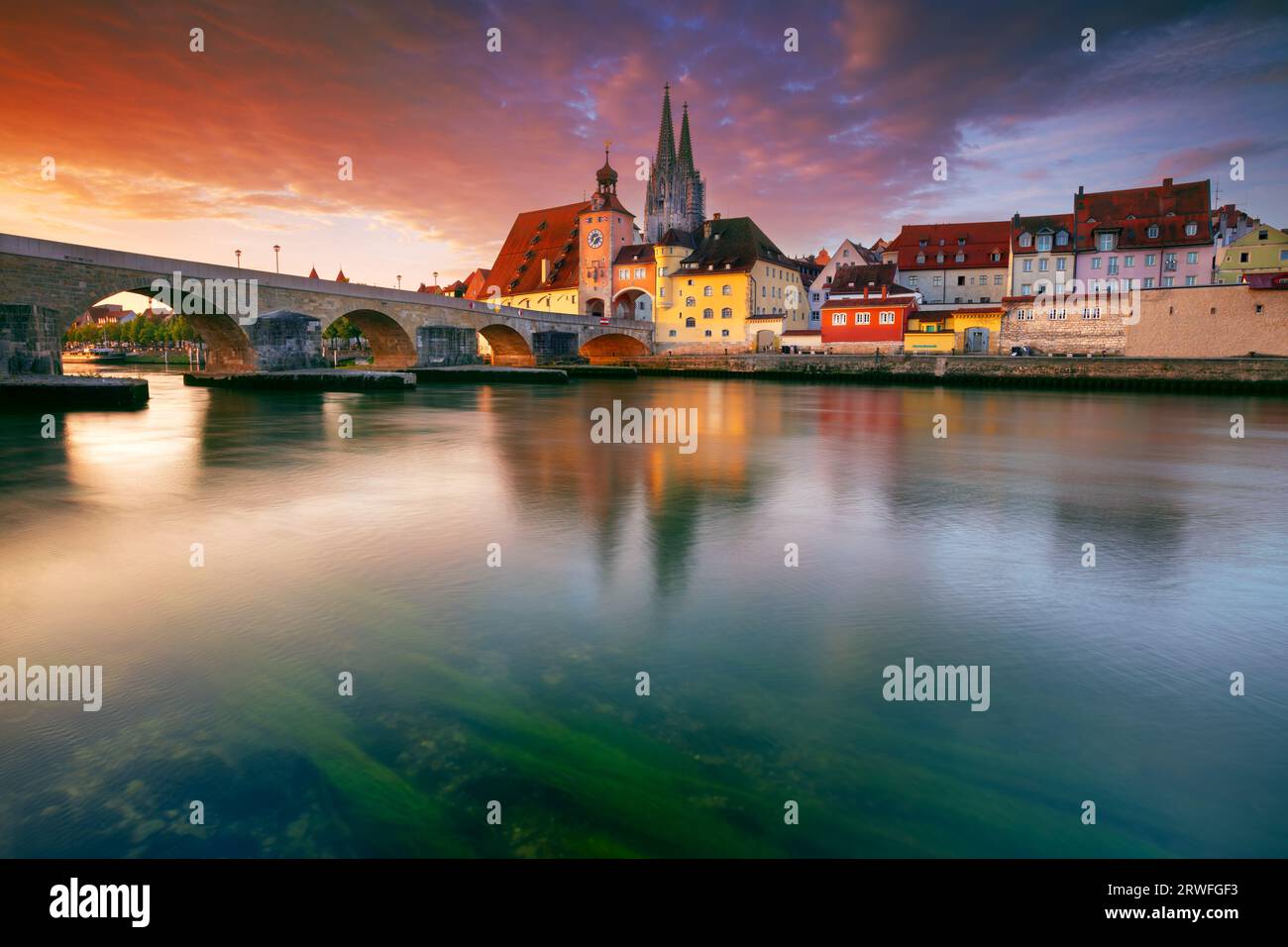 Regensburg, Deutschland. Stadtbild von Regensburg, Deutschland mit alter Steinbrücke über Donau und St. Peter Kathedrale bei Herbstsonnenaufgang. Stockfoto