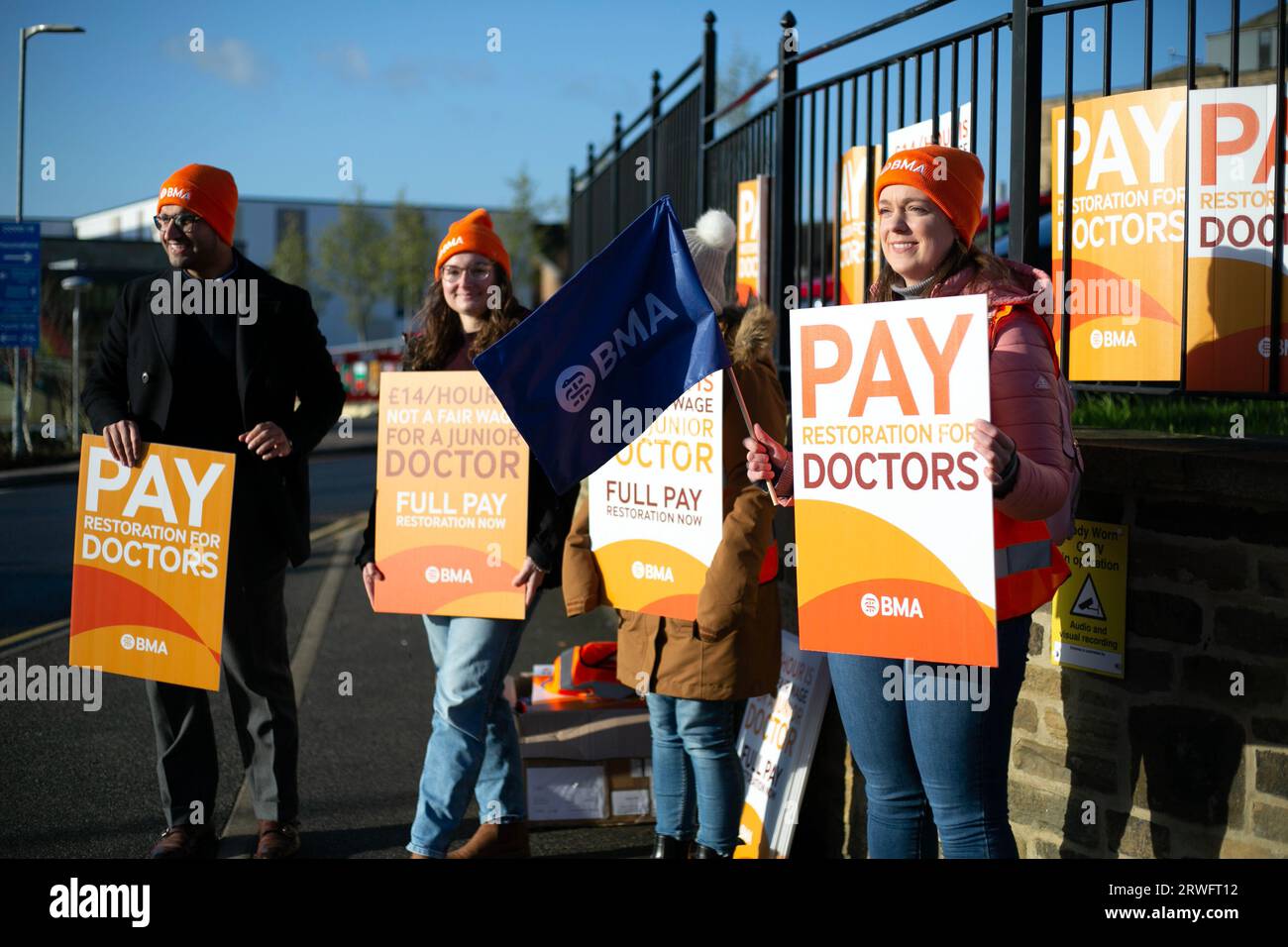 Juniorärzte und Mitglieder der British Medical Association (BMA), die im Morgenlicht auf der Streikpostenlinie vor der Royal Bradford Infirmary zuschlagen Stockfoto