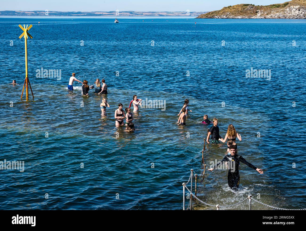 Kinder schwimmen im Meer bei heißem Sommerwetter, North Berwick Hafen, East Lothian, Schottland, Großbritannien Stockfoto