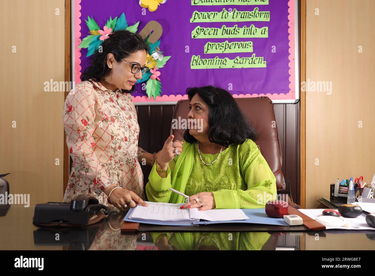 Schuldirektor Mam überprüft wichtige Dokumente in einer Akte mit ihrem