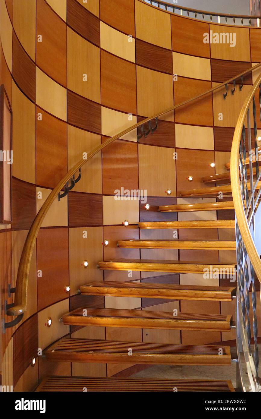 Die weitläufige runde Treppe ist mit polierten Holzpaneelen ausgestattet, die die Champions Bar mit dem Glass House Restaurant an Bord des P&O's Aurora verbinden. Stockfoto