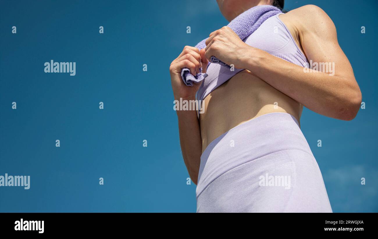 Nahaufnahme einer sportlichen Frau, die nach dem Training ein Handtuch hält. Stockfoto