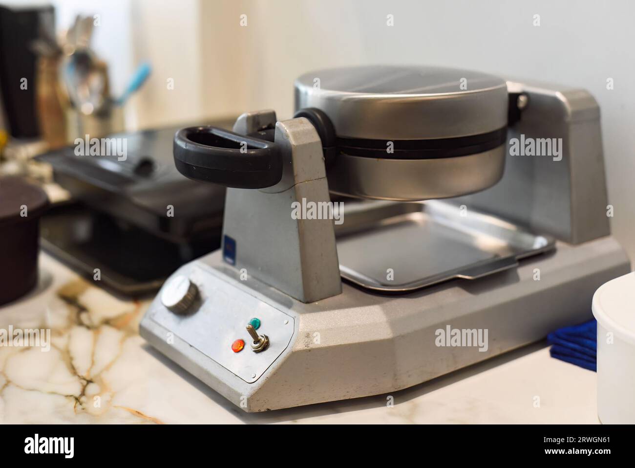 Waffeleisen-Maschine auf dem Tisch in der Cafeküche Stockfoto