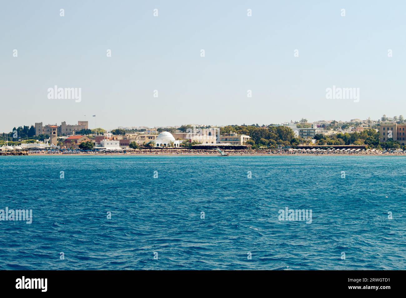 Beliebter Elli Strand oder Paralia Enidriou auf der Insel Rhodos in Griechenland, Europa. Beliebter Sandstrand in der Stadt an sonnigen Sommertagen, klarer blauer Himmel. Stockfoto