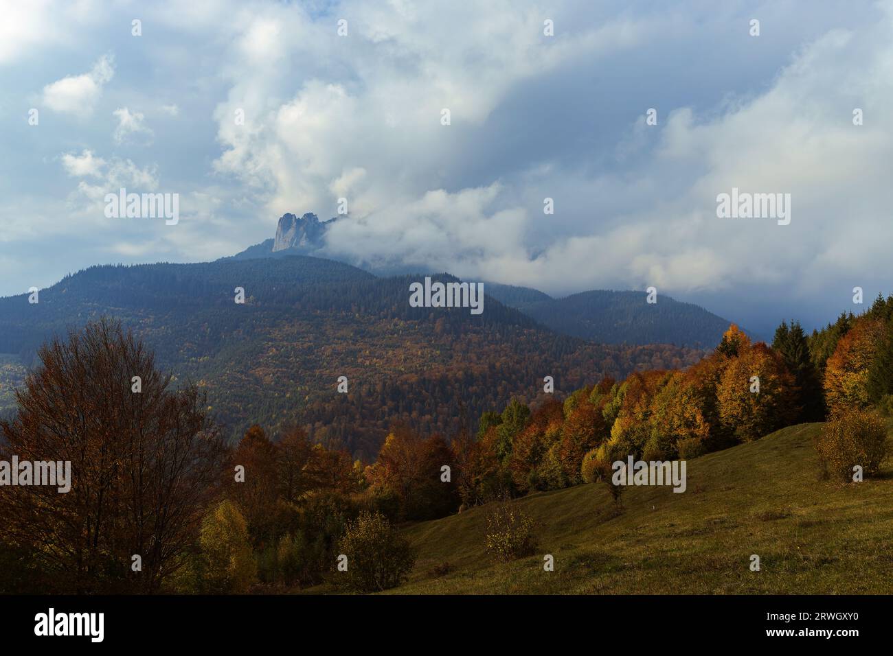 Der Ceahlau Mountain im rumänischen Neamt hat von weitem beobachtet, da er vor dem Regen von Wolken bedeckt war, an einem wunderschönen Oktobertag. Stockfoto
