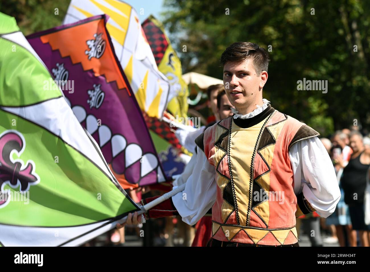 Badacsony, Balaton-See, Ungarn - 10. September 2023 - Straßenparade des Weinerntefestes, junger Mann in traditioneller Tracht, der eine Flagge dreht Stockfoto