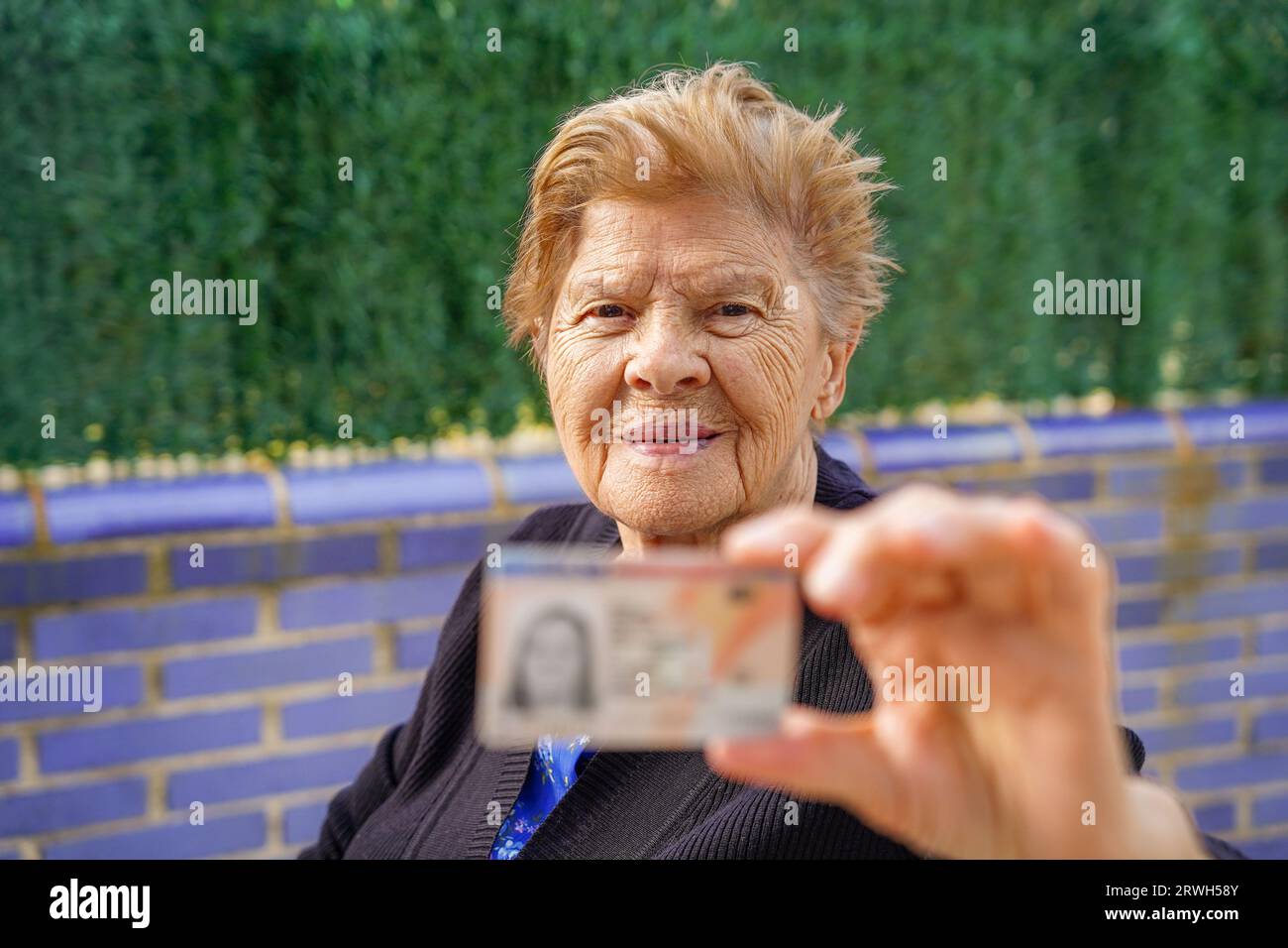 Pensionierte Frau mit nationalem Ausweis. Altersidentifizierung und Persönlichkeitsrechte. Spanischer Reisepass, Personalausweis Stockfoto