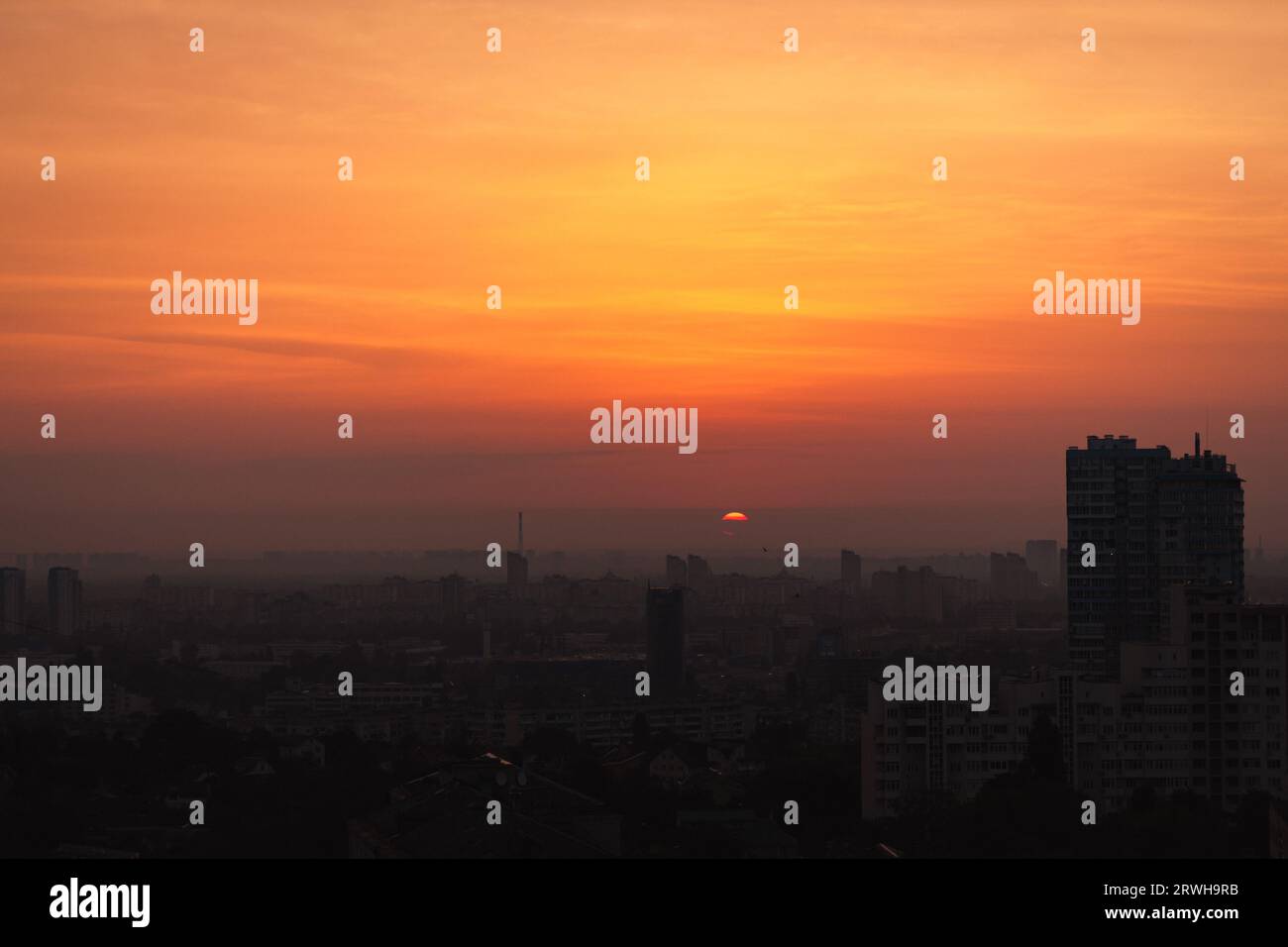 Sonnenaufgang über der Stadt. Morgengradientenhimmel über Kiew, Ukraine. Morgenhimmel in der Abenddämmerung über Gebäuden. Himmel am Abend in der Innenstadt. Malerischer Sonnenuntergangshimmel Stockfoto