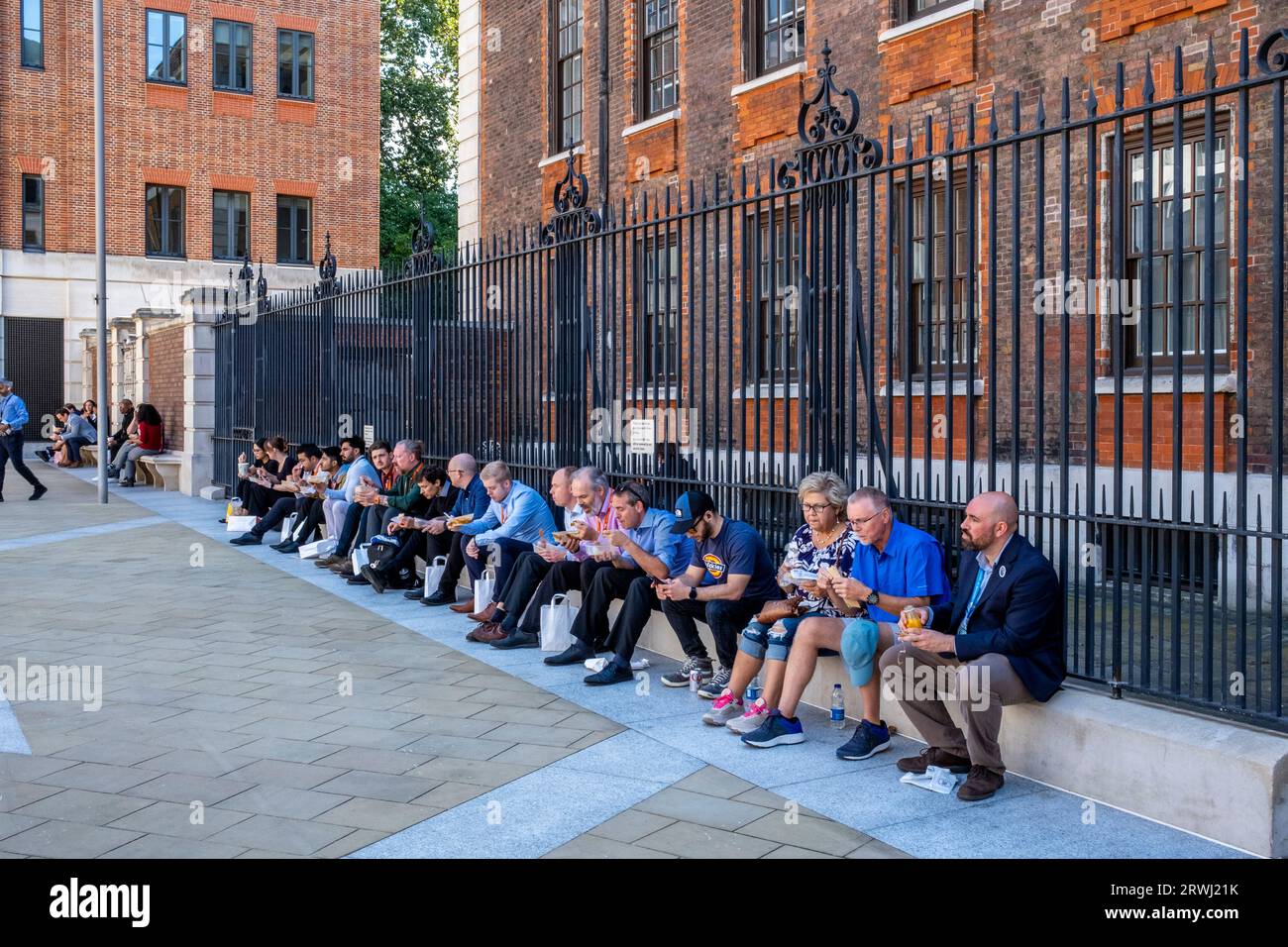 Büroangestellte sitzen beim Mittagessen, Paternoster Square, City of London, London, UK. Stockfoto