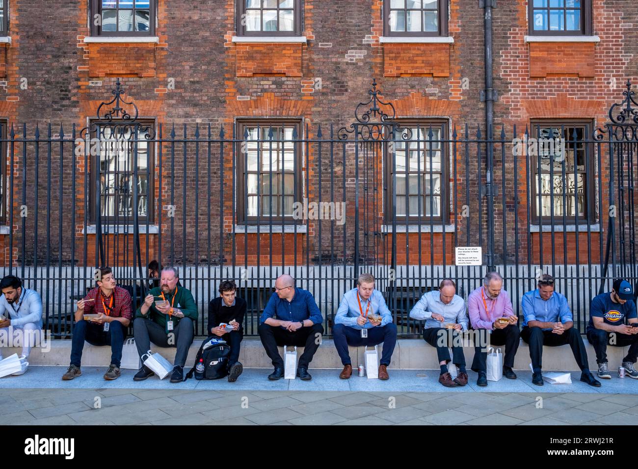 Büroangestellte sitzen beim Mittagessen, Paternoster Square, City of London, London, UK. Stockfoto