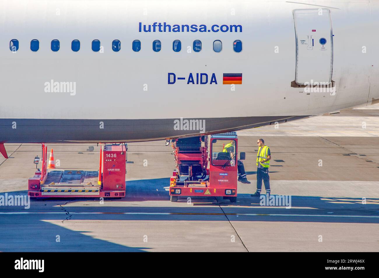 Hamburg, Deutschland - 17. Juli 2014: Das Personal des Bodenbetriebs hat eine kurze Pause und talt beim Laden des letzten Gepäcks in den Bauch von Lufthansa-Flugzeugen. Stockfoto