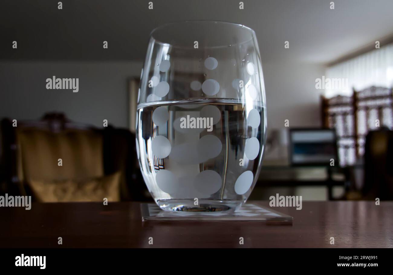 Glas halb voller Wasser isoliert unscharfer Hintergrund Stockfoto