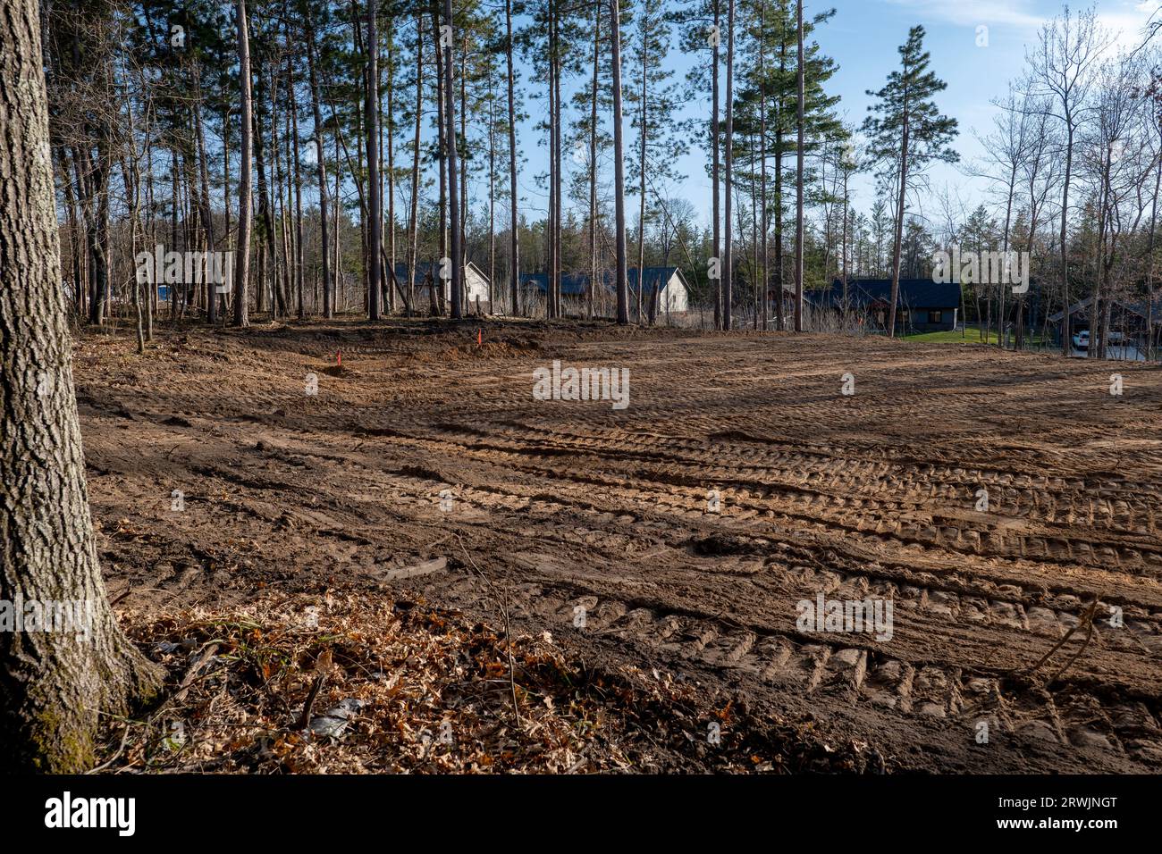 Leeres Baugrundstück, mit ebenem Boden und vorbereitet für den zukünftigen Bau eines neuen Hauses, in einer schönen Nachbarschaft. Stockfoto