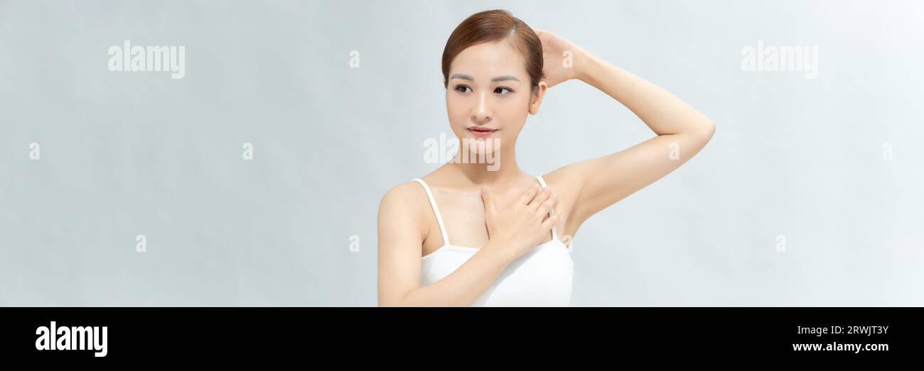 Junge asiatische Frau, die die Hände hochhebt, um saubere und hygienische Achselhöhlen oder Achselhöhlen zu zeigen. Banner Stockfoto