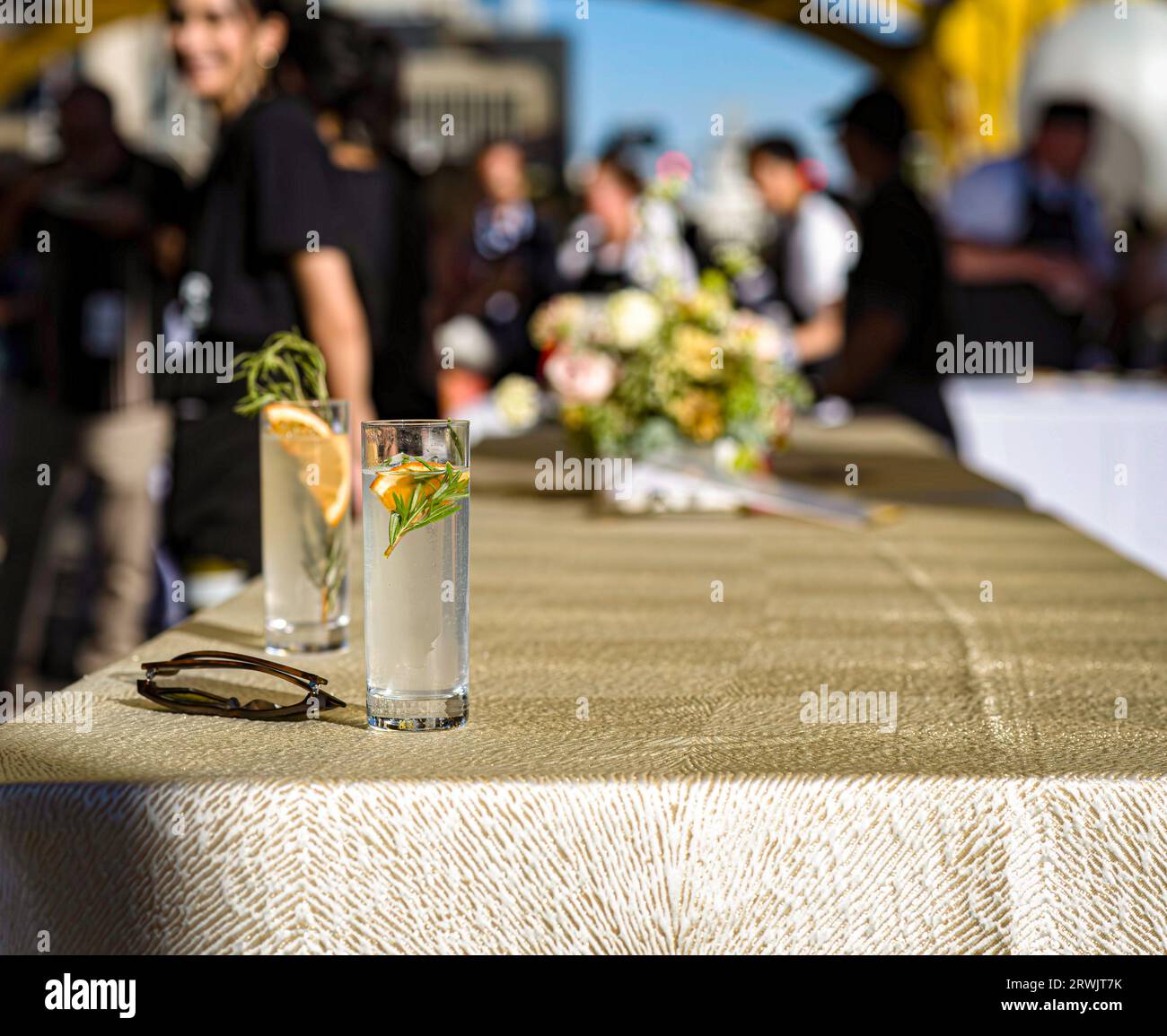 Selektiver Fokus von zwei Cocktailgläsern und einem langen Tisch beim jährlichen berühmten Farm-to-Fork Festival Tower Bridge Dinner, veranstaltet von Visit Sacramento. Stockfoto