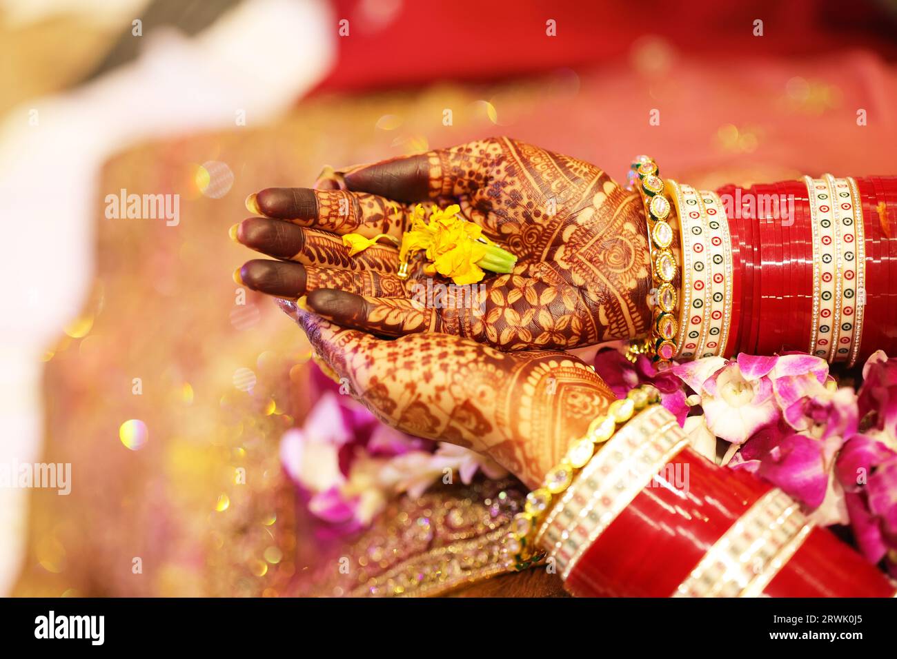 Nahaufnahme der Blume in Brauthänden von oben, Hände mit Henna verziert Stockfoto