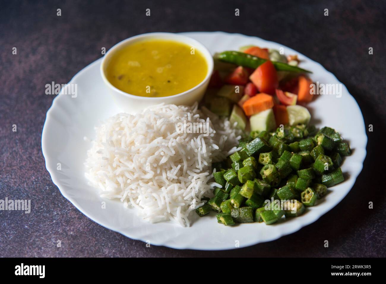 Gesunde indische Gemüse Mahlzeit Reis, dal, Gemüse und Salat auf einem Teller serviert. Stockfoto