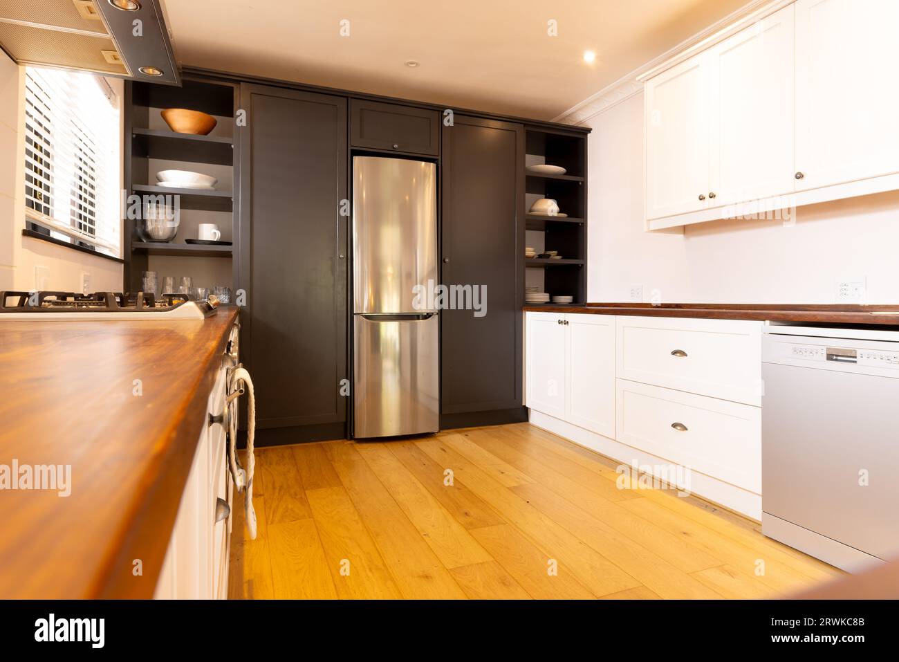 Geräumige, moderne Küche mit Haushaltsgeräten und Holzboden Stockfoto