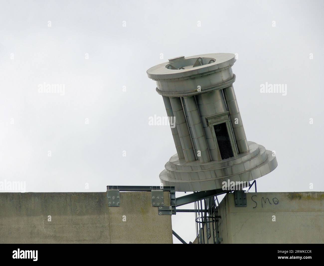 Eisenskulptur auf einem Nebengebäude des römischen Kraftwerks in Saarbrücken, Hintergrund grauer Himmel Stockfoto