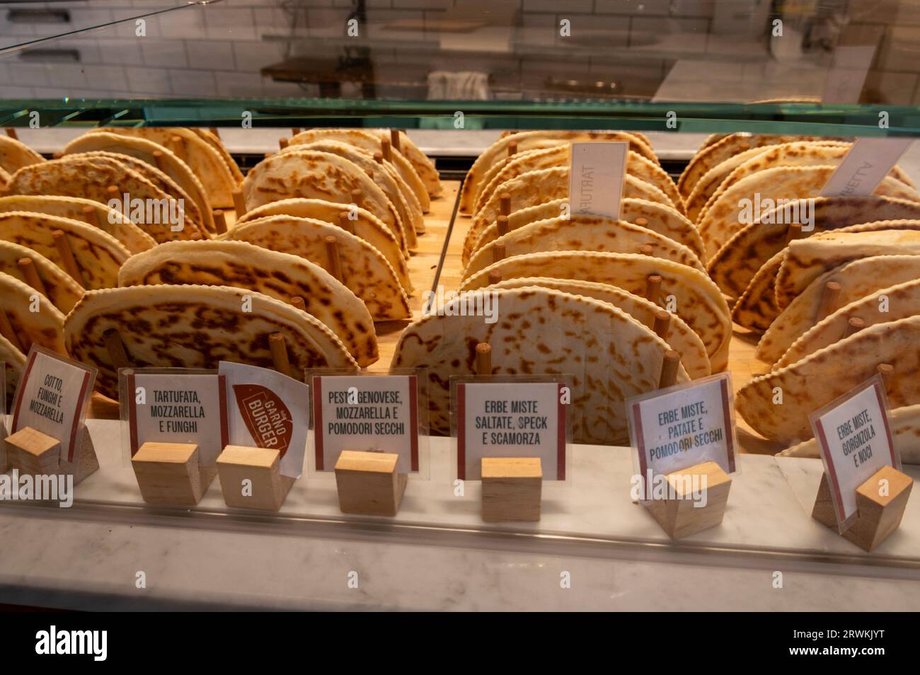 Die vielen Aromen frisch gebackener halbgroßer Pizzas, die in einem der vielen Pizzasalons in Bologna in der Emilia-Romagna-Region, Norditalien, angeboten werden Stockfoto