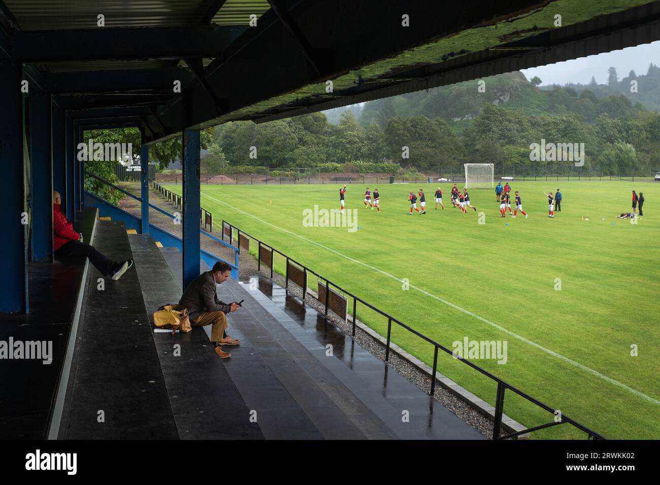 Die Spieler des Auswärtsteams, die sich aufwärmen, bevor Oban Camanachd Kingussie in einem glanzvollen Spiel der Premiership im Mossfield Park in Oban spielt. Die Heimmannschaft wurde 1889 gegründet und war schon immer einer der führenden Vereine in diesem Sport, der fast ausschließlich in Schottland spielte. Die Besucher gewannen diese Begegnung in der obersten Liga mit 2 Toren zu 1, beobachtet von einer Menge von rund 100 Zuschauern. Stockfoto