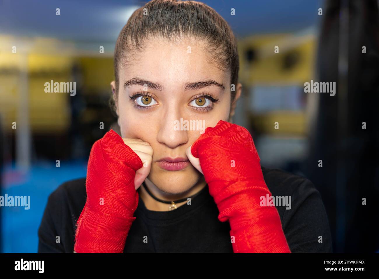 Nahaufnahme des weiblichen Boxerporträts in Schutzstellung in einem Boxring. Kampfsport-Training. Stockfoto