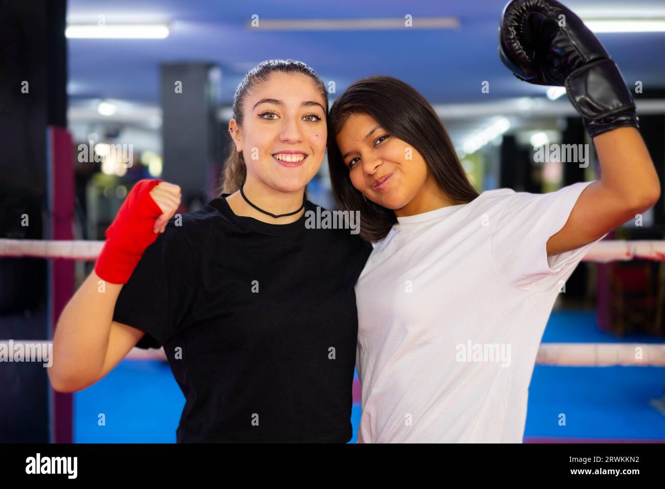 Zwei multiethnische Boxerinnen-Porträts in einem Boxring. Kampf gegen den Sport. Stockfoto