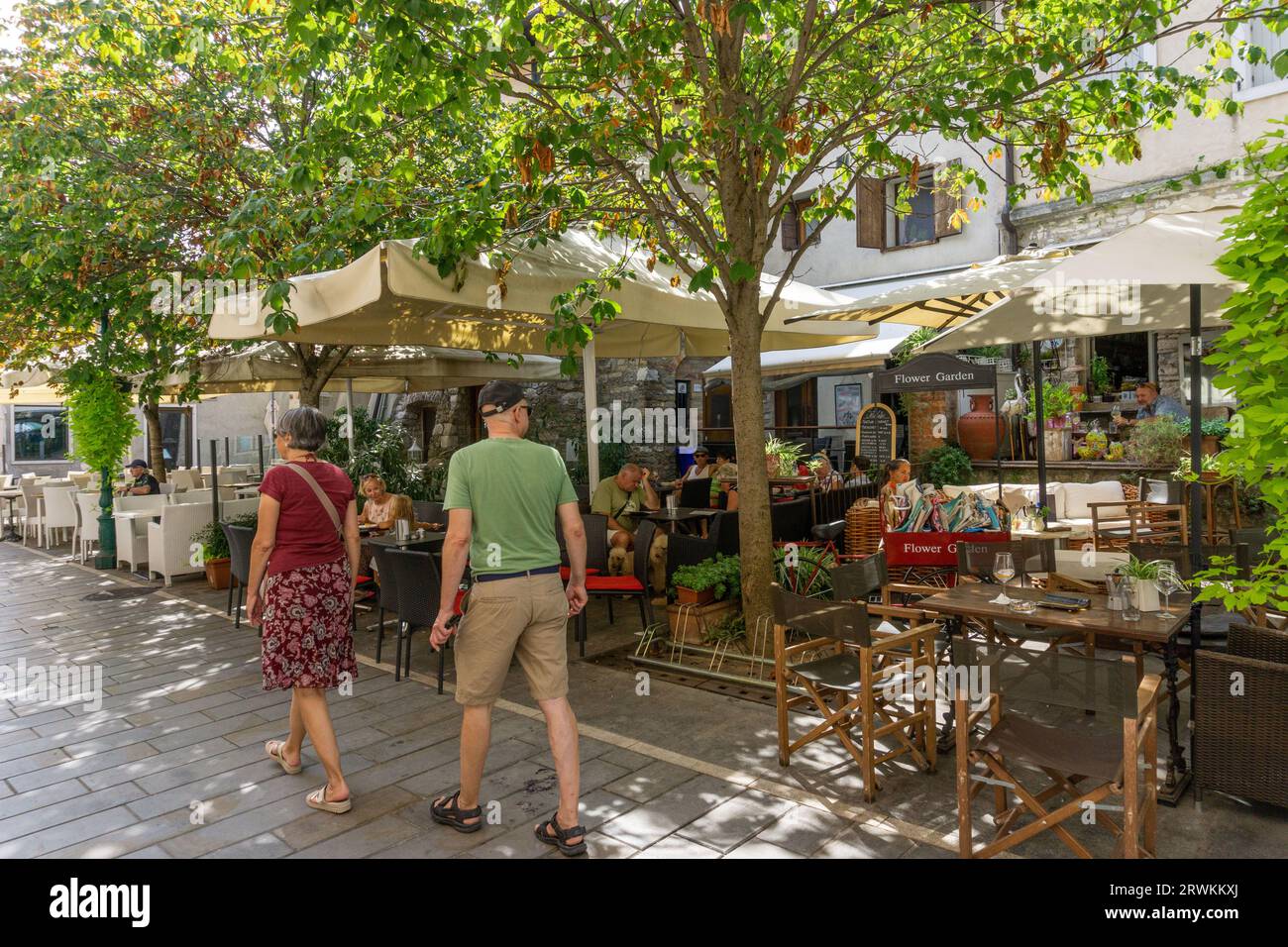 Eine Straßenszene in Grado, die ein Straßencafé und Fußgänger zeigt Stockfoto
