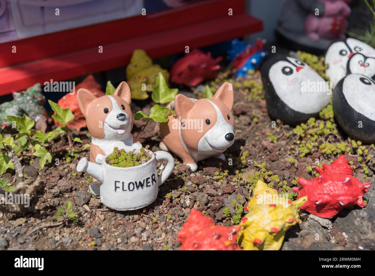 Zwei kleine Korgis-Skulpturen und ein Blumentopf. Stockfoto