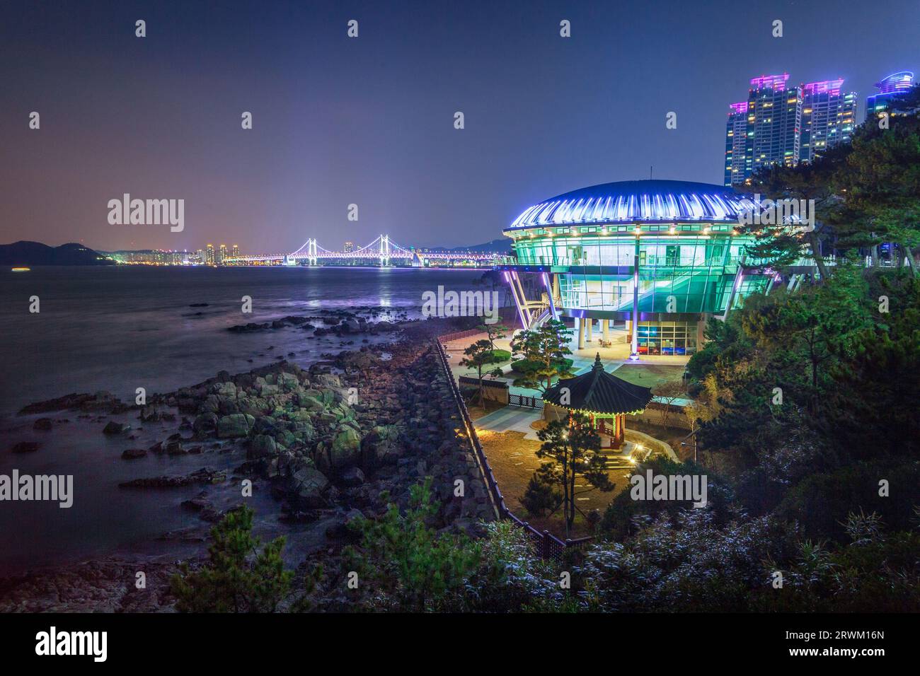 Der nächtliche Blick auf eine Stadt mit einem Strand und einer Brücke Stockfoto