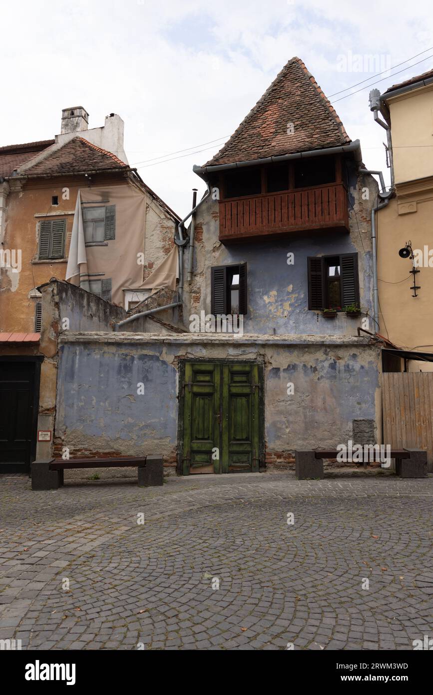 Altes Haus mit spitzem Dach und Wänden mit flackernder blauer Farbe in Sibiu, Transsilvanien, Rumänien Stockfoto