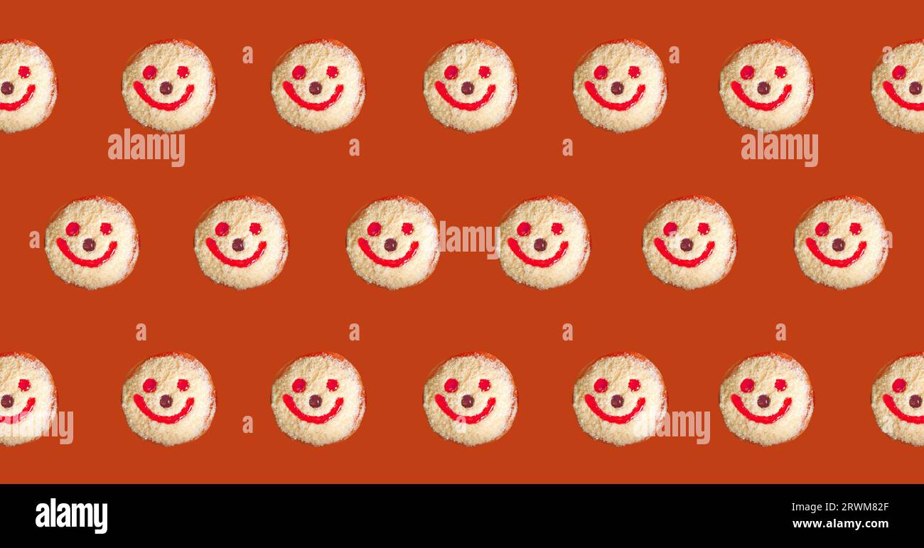 Lächelndes Gesicht Coconut Flakes Jelly Donuts Muster auf rötlich braunem Hintergrund Stockfoto