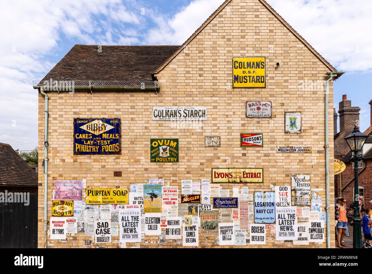 Vintage-Werbeschilder und Plakate an der Seite eines Gebäudes in Blists Hill Victorian Town, Telford, England Stockfoto