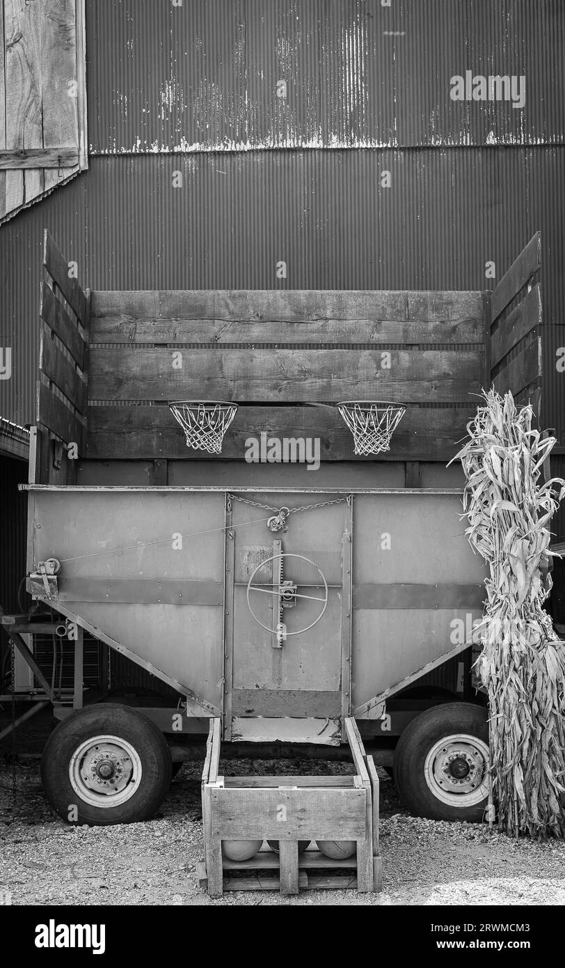 Ein Schwarzweißbild eines großen Lkws, der vor einem Gebäude geparkt ist und dessen Hintergrund unscharf ist Stockfoto