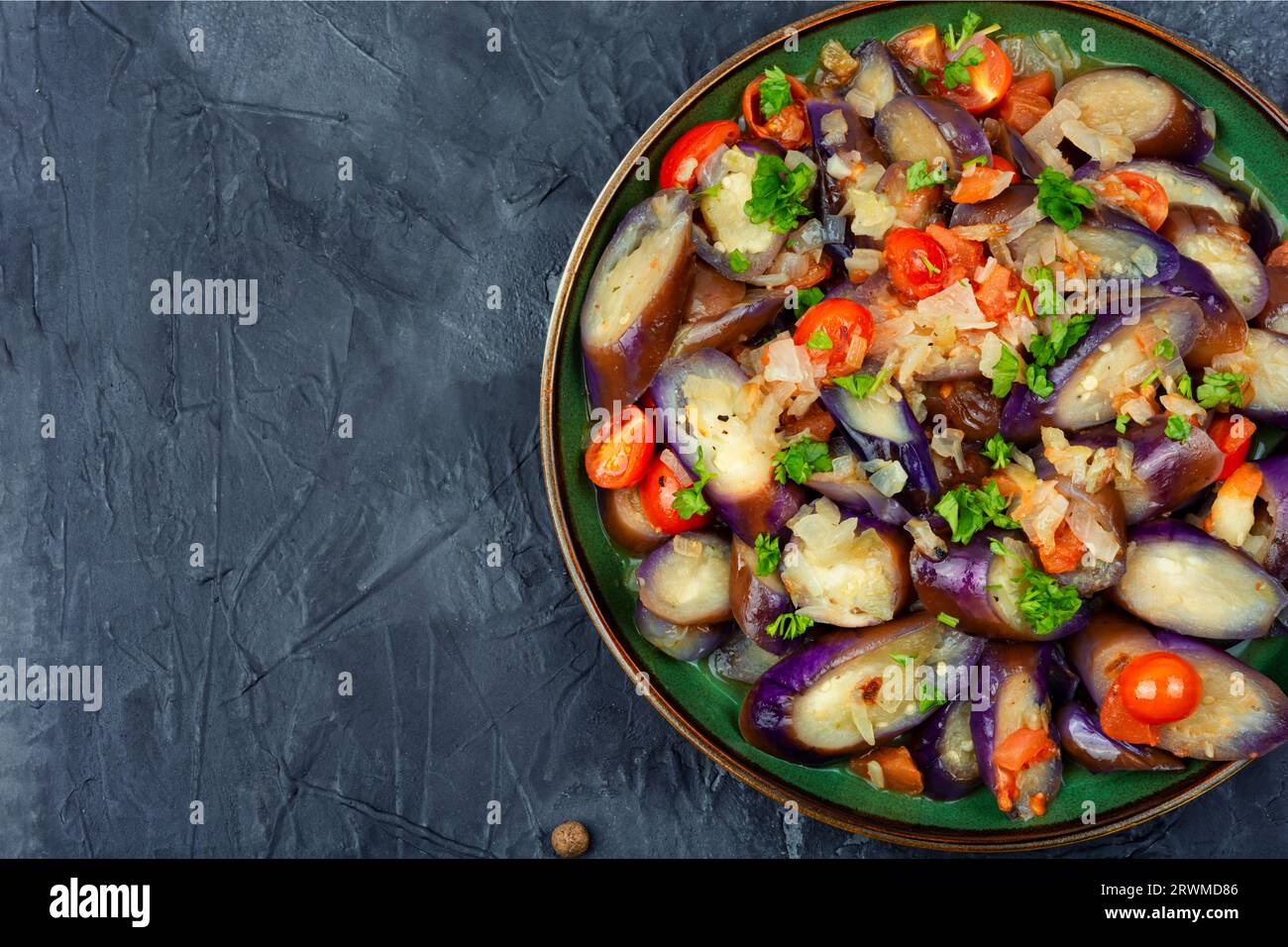 Warmer lila Auberginen-, Tomaten- und Knoblauchsalat. Leerzeichen für Text kopieren Stockfoto