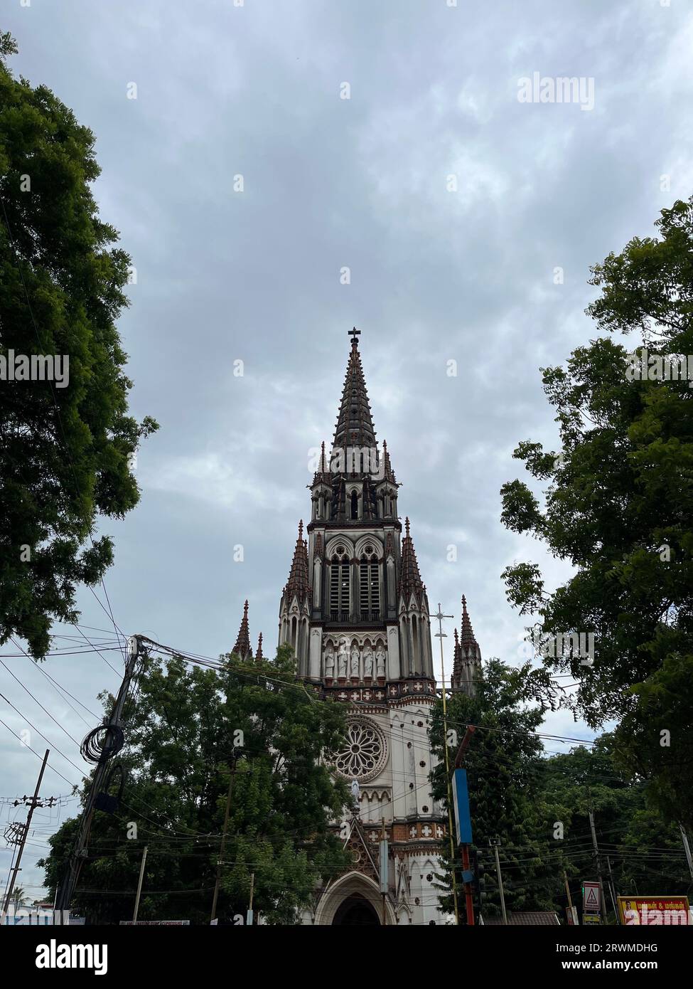 Die Kirche Our Lady of Lourdes, umgeben von üppigen grünen Bäumen in Indien Stockfoto