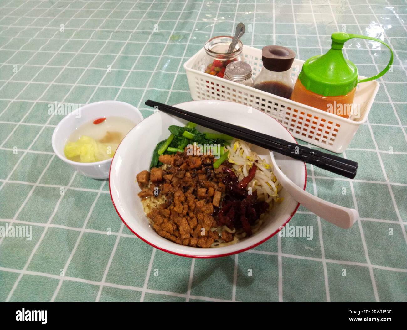 Eine Schüssel mit herzhaften und köstlichen veganen Nudeln. Serviert mit veganen Nudeln, knusprigen Crepes, veganem Charsio, Sojasprossen, frischem Gemüse, gehackte Chilis Stockfoto
