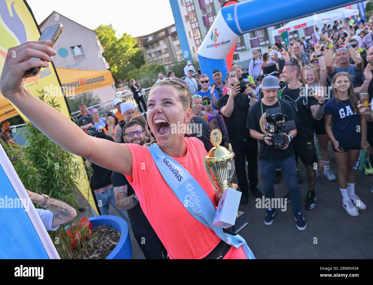 20. September 2023, Brandenburg, Frankfurt (oder): Joyce Hübner, Athletin, wird nach ihrem Abschluss der Tour of Germany von vielen Fans gefeiert. Start und Ziel war die Stadtbrücke in Frankfurt (oder). Joyce Hübner hat nun 120 Marathons hintereinander gelaufen und eine Strecke von 5.200 Kilometern entlang der deutschen Grenze zurückgelegt. Mit diesem Projekt möchte der Extremsportler andere Menschen dazu inspirieren, ihre Komfortzone zu verlassen und zu zeigen, wie das Testen Ihrer persönlichen Grenzen nachhaltig positive Auswirkungen auf Sie haben kann. Foto: Patrick Pleul/dpa Stockfoto