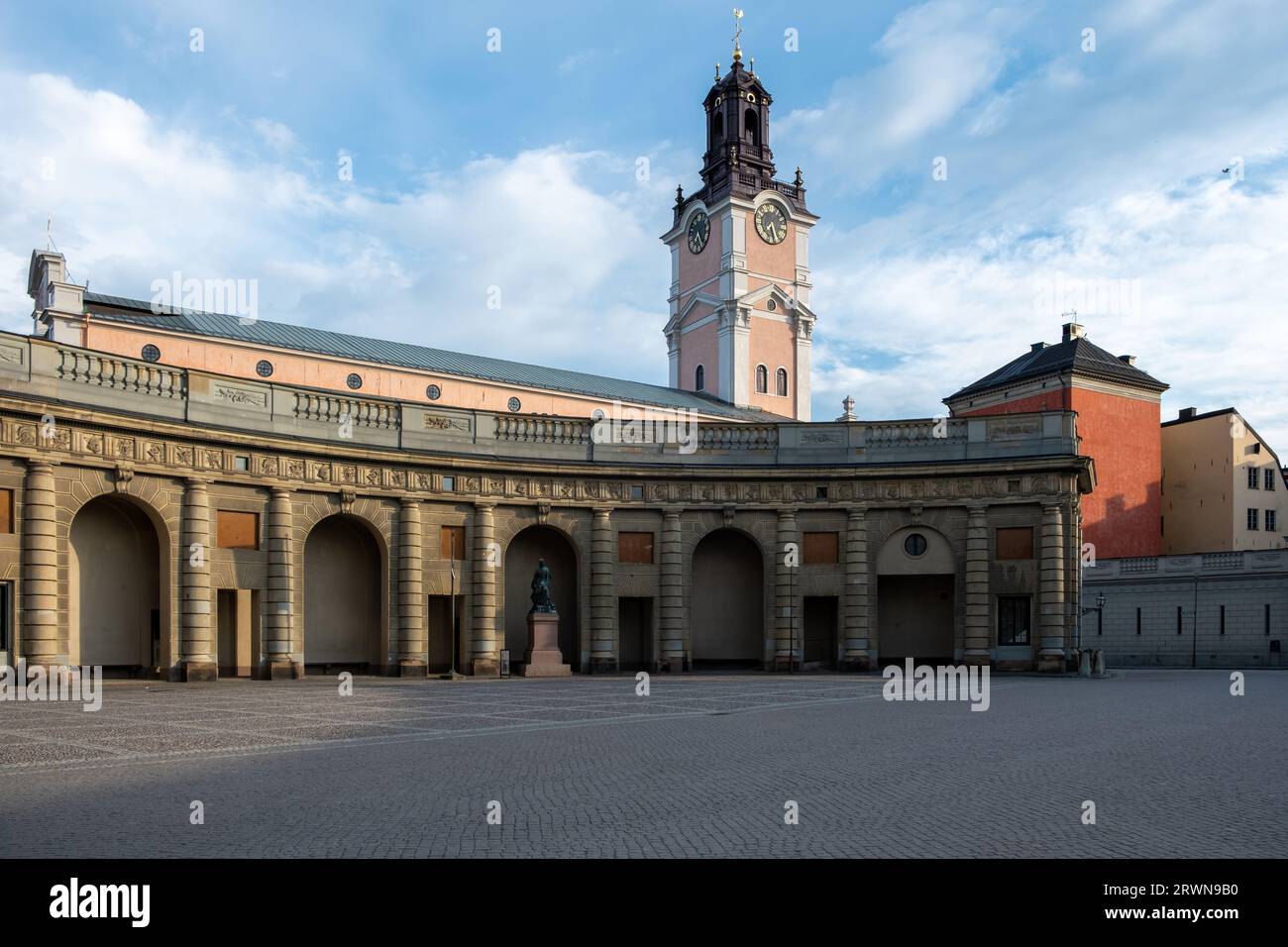 Königliches Schloss Stockholm Schweden. Schwedisches Wahrzeichen, historisches berühmtes Gebäude in Gamla Stan mit Statue, gepflastertem Hof, bewölktem Himmel Hintergrund. Stockfoto