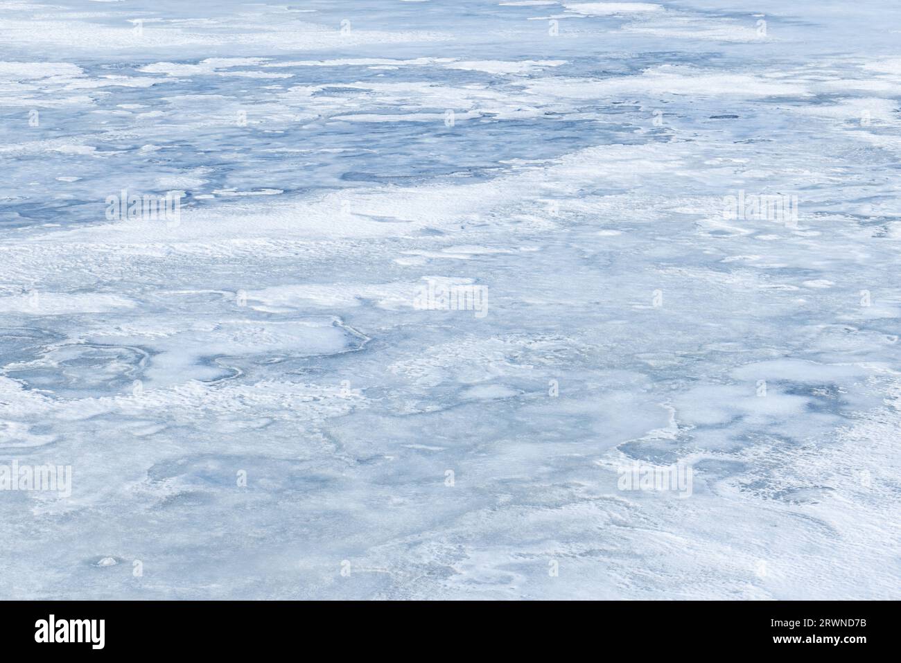 Eis und Schnee bedeckt einen gefrorenen Fluss in der Wintersaison, natürliche Hintergrund Foto Textur Stockfoto