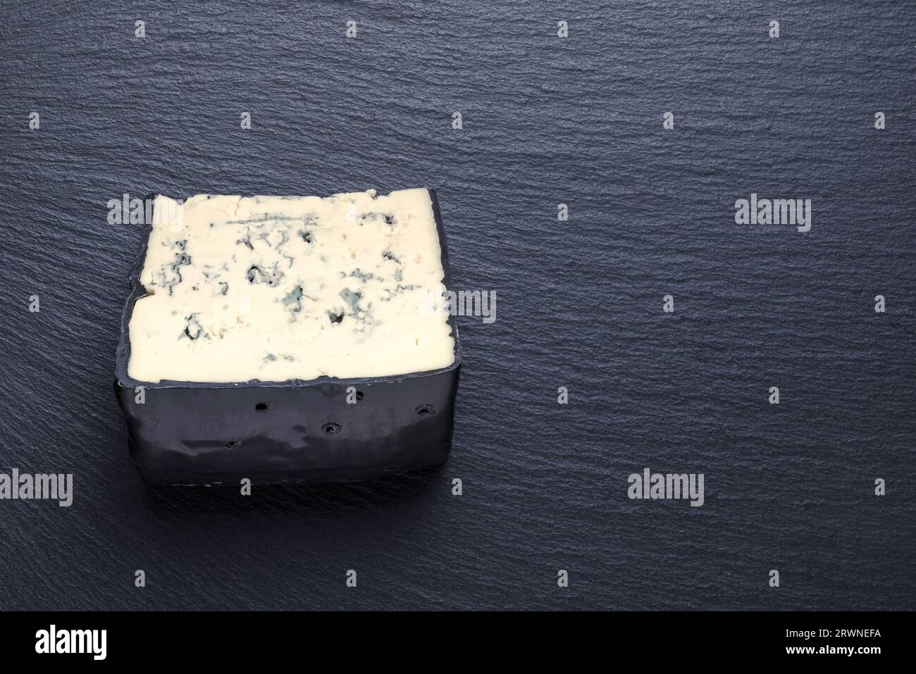 Draufsicht auf leckeren Stückkäse mit blauem Schimmel auf schwarzem Schieferhintergrund, Kopierraum. Stockfoto