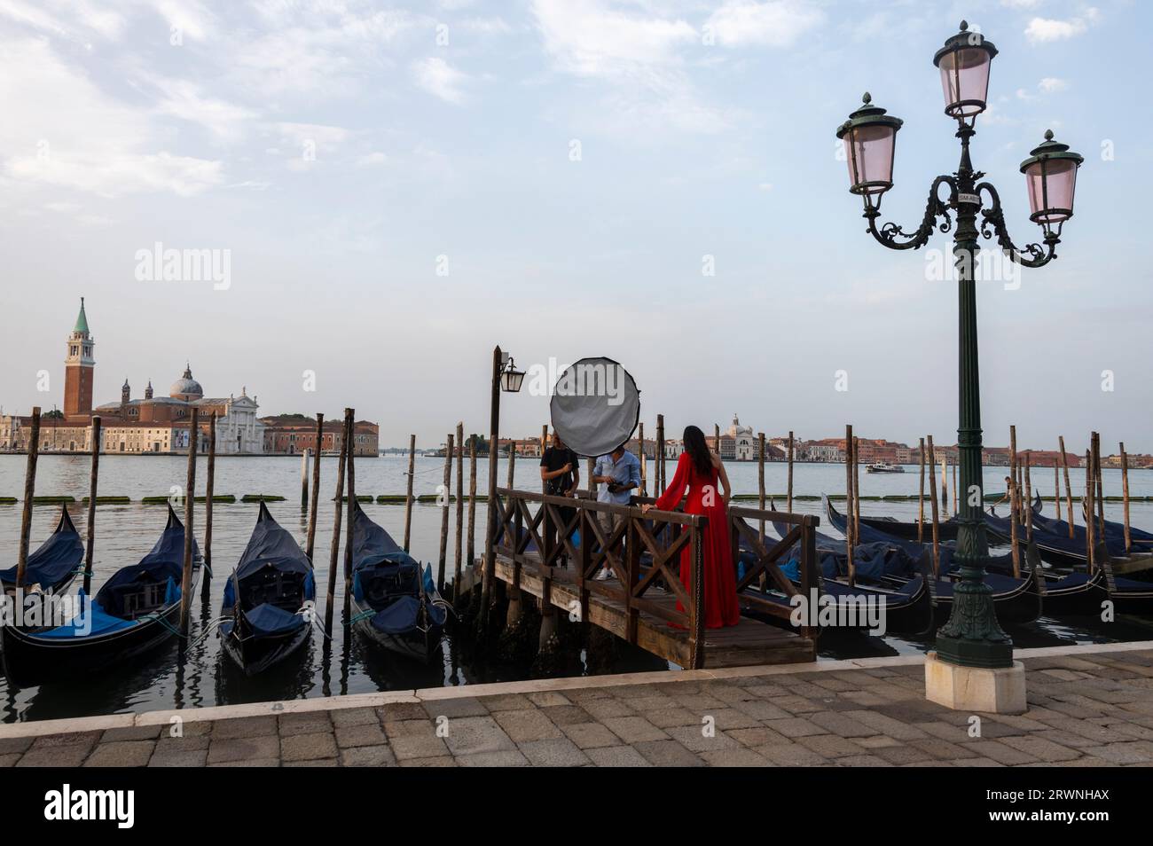 Ein Foto-Fashion-Shooting auf einer Landungsbühne auf dem Markusplatz. Auf der anderen Seite der Lagune von Piazza San Marco (Markusplatz) bei Tagesanbruch, befindet sich die 63 m Stockfoto