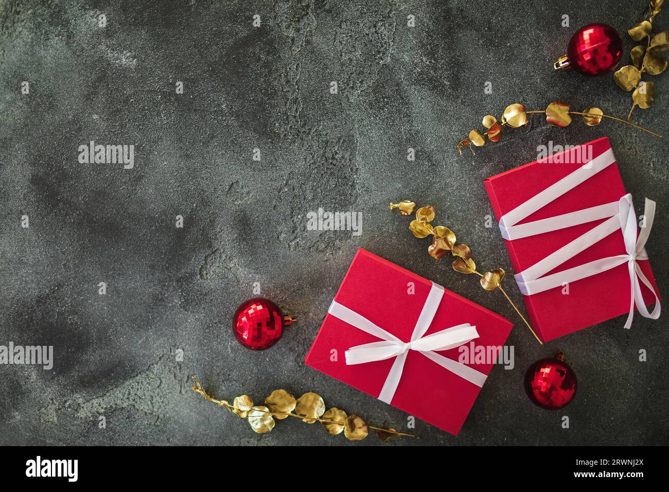 Weihnachtliche Komposition mit goldenen Zweigen, Geschenken und Dekoration im Dunkeln. Flach liegend Stockfoto