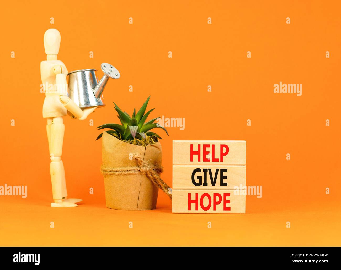 Hilf, das Symbol Hoffnung zu geben. Konzept Wort helfen Hoffnung auf schönen Holzblock zu geben. Geschäftsmann-Modell. Schöner oranger Tisch mit orangefarbenem Hintergrund. Geschäftsmonat Stockfoto
