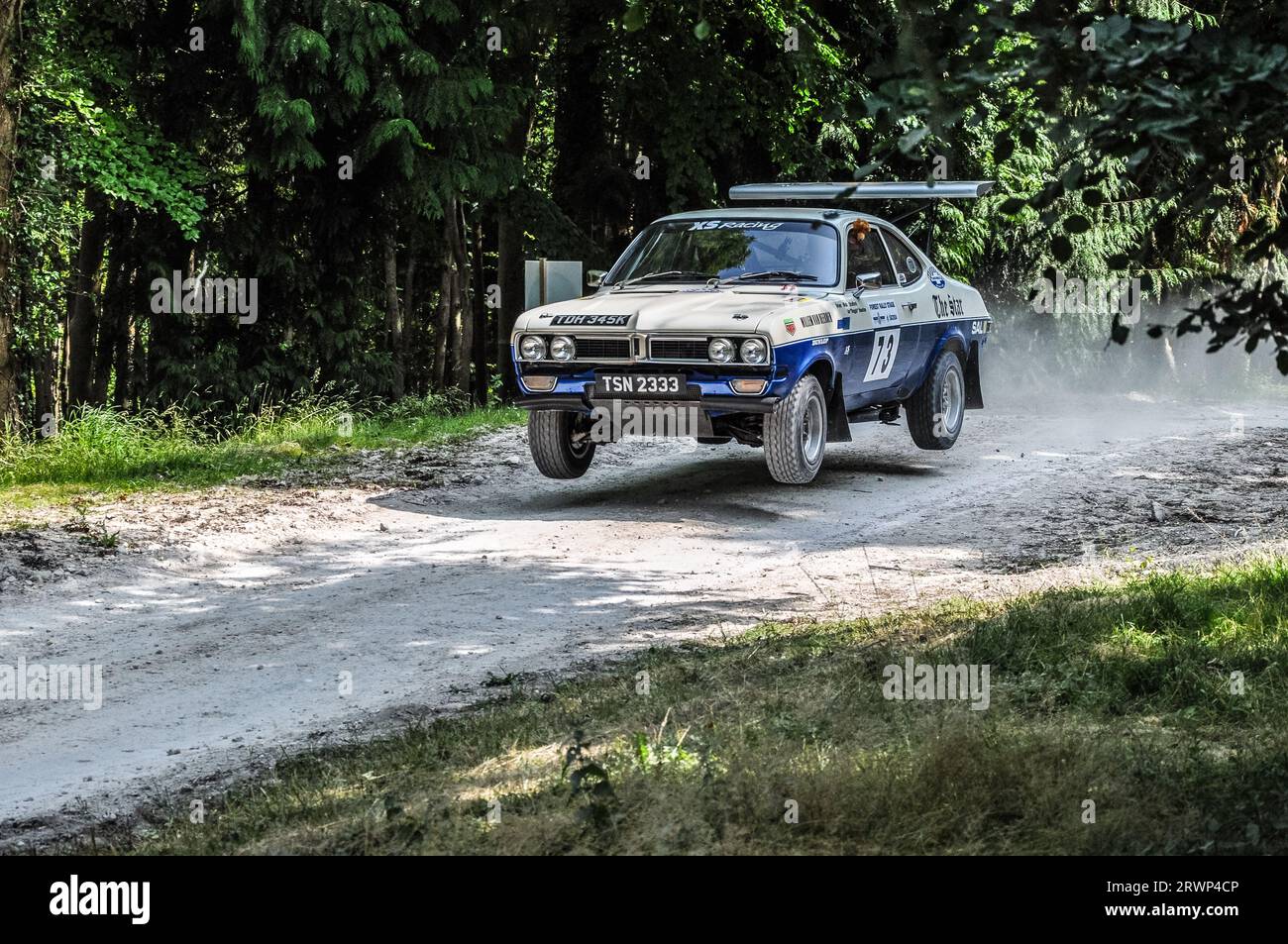 Vauxhall Firenza Rallye-Auto springt durch den Wald beim Goodwood Festival of Speed Motorsport Event, UK. 1972 gebautes Auto Stockfoto